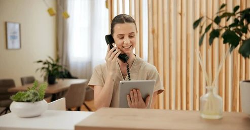 MedSpa receptionist handling multiple tasks while phone lines go unanswered